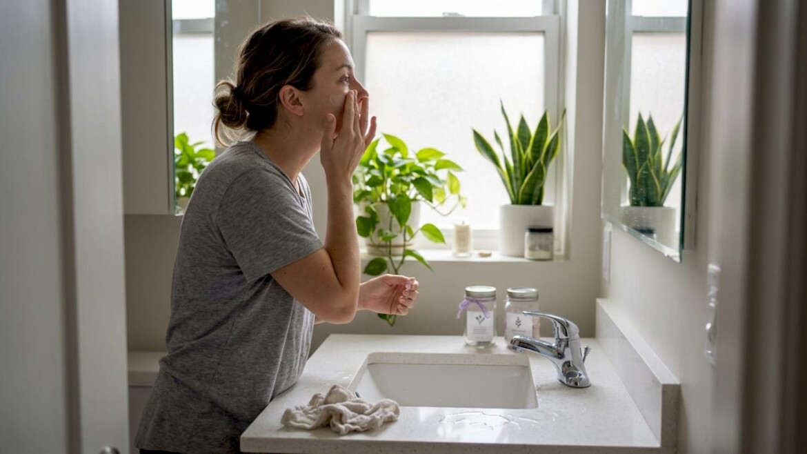 Woman using vegan skincare in home bathroom