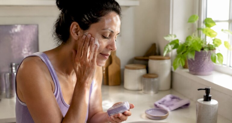 Woman washing face with pH balanced soap
