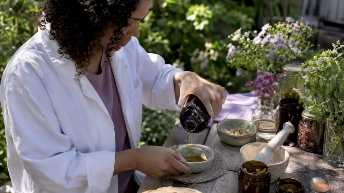 Artisan pouring unrefined oil in skincare workshop