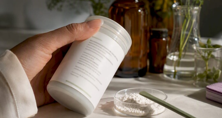 Hand inspecting an anonymous skincare ingredient label