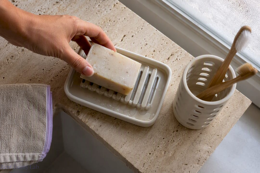 Soap bar resting on draining ceramic dish