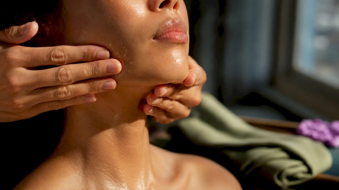 Hands performing an oil face massage