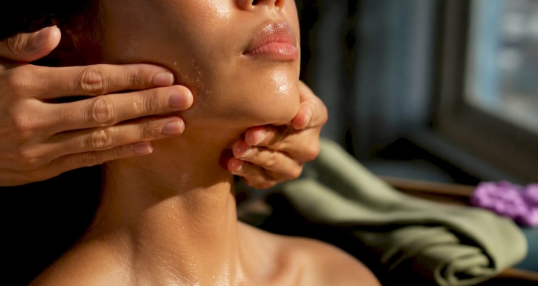 Hands performing an oil face massage