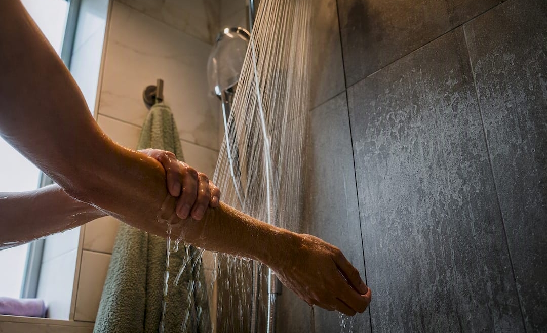 Hands rinsing hard-water residue from skin